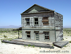 Sitting to the side of the Tombstone Saloon, this fixer-upper appears to have lost two huge sections of its housing, seen on the ground. The sign next to the door reads, ''For Sale.'' Photo copyright 2003-2004 Mike Durrett, all rights reserved.